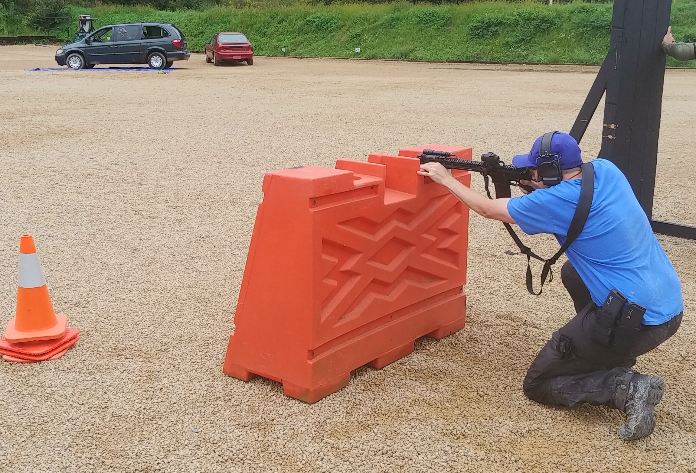 Kneeling tactical shooting in Fjallraven trousers.