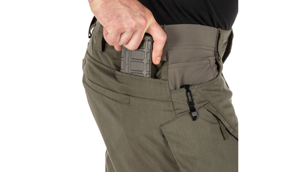 man putting magazine in pocket of tac pants