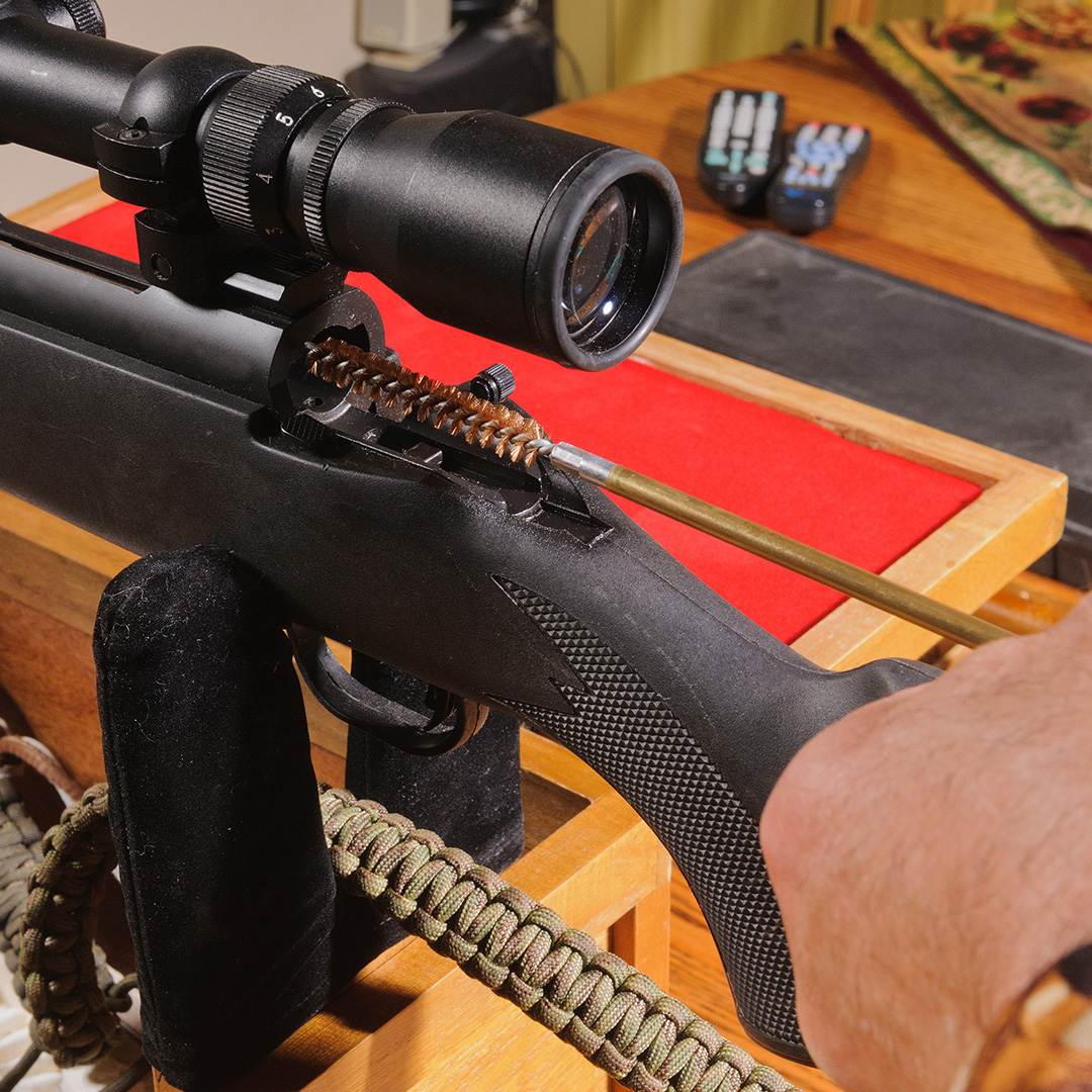 Bolt-action rifle being cleaned from action toward muzzle.