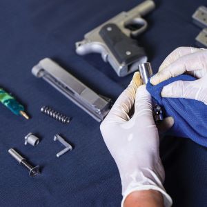 man cleaning gun with kit supplies